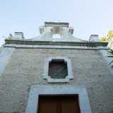 ...con finestrella centrale dominata da un cornicione in pietra che culmina con un piccolo campanile decorato a volute
